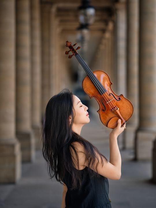 Anna Lee in profile looking up at her violin