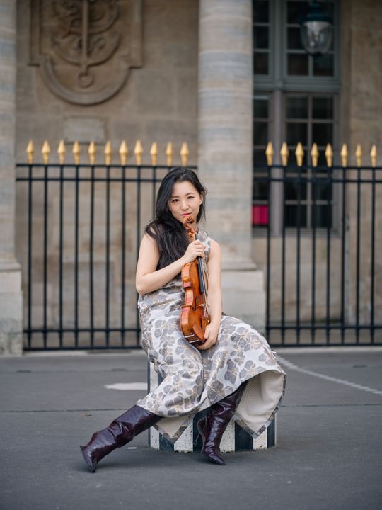 Anna Lee seated among the black-and-white columns at Palais-Royal