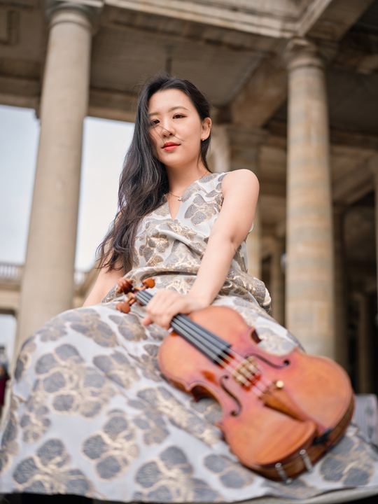 Anna Lee seated with her violin