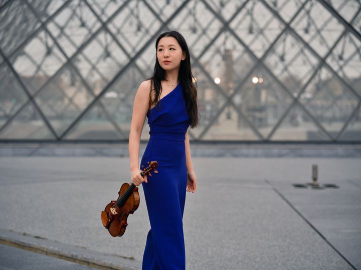 Anna Lee in blue before the Louvre Pyramid