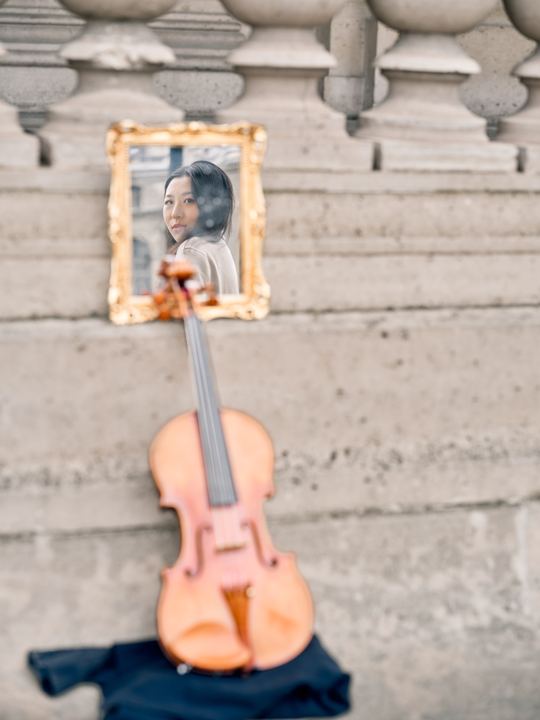 Anna Lee’s violin resting on stone steps beside a small portrait